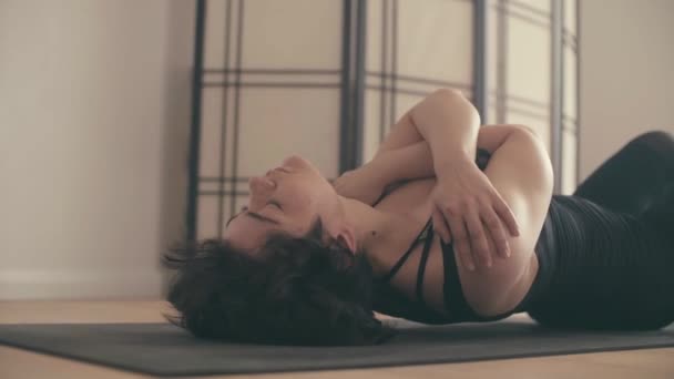 Молода жінка, що виконує йогу-сасану в залі . — стокове відео