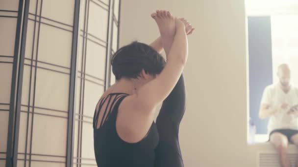 Eine junge Frau, die Yoga-Asanas macht — Stockvideo