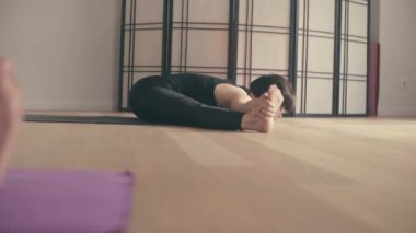 Genç bir kadın Yoga-asanas koridorda gerçekleştirme.