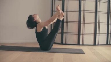 Genç bir kadın Yoga-asanas koridorda gerçekleştirme.
