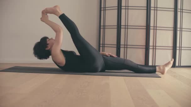 A young woman performing yoga-asanas in the hall. — Stock Video