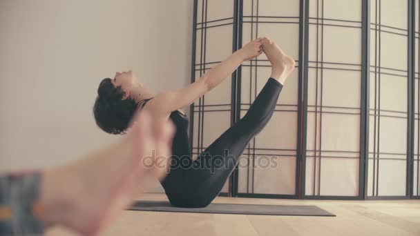 En ung kvinna som utför yoga-asanas i hallen. — Stockvideo