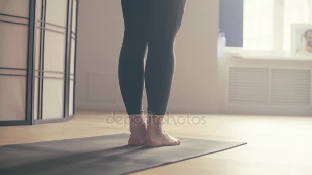 En ung kvinna som utför yoga-asanas — Stockvideo