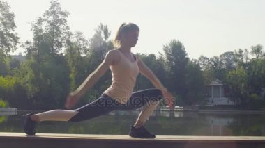 Parkta yoga egzersizi yapan genç bir kadın.