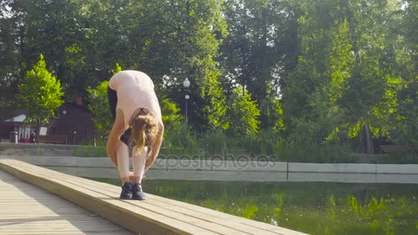 Νεαρή γυναίκα που κάνει ασκήσεις γιόγκα στο πάρκο — Αρχείο Βίντεο