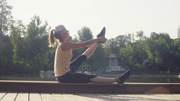 Mujer joven haciendo ejercicios de yoga en el parque — Vídeos de Stock