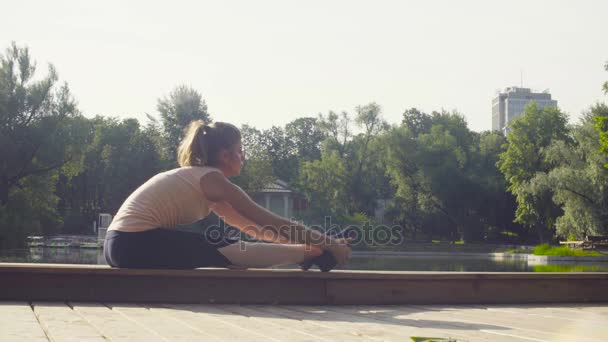 Junge Frau macht Yoga-Übungen im Park — Stockvideo