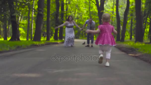 Kleines Mädchen rennt zu ihren Eltern — Stockvideo