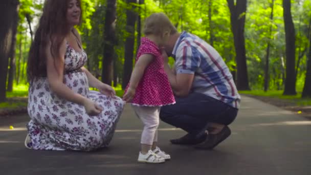 Lyckliga föräldrar med baby flicka i en park — Stockvideo