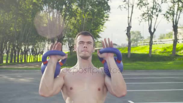 Crossfit. A young man is lifting dumbbells — Stock Video