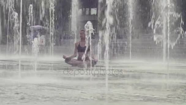 Young woman meditating inside the fountain — Stock Video