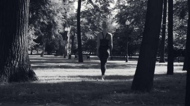 Молодая женщина ходит босиком по траве — стоковое видео