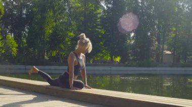 Parkta yoga egzersizi yapan genç bir kadın.