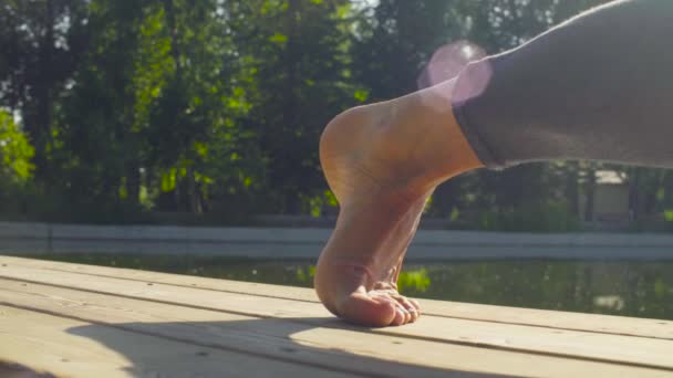 Foten av en kvinna gör yogaövningar i parken — Stockvideo