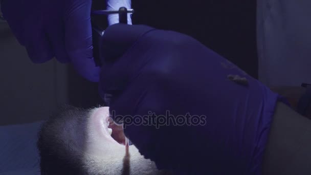 Dentista colocando algo sobre os pacientes dente — Vídeo de Stock