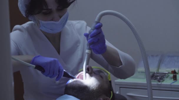 Dentista cura dente na clínica odontológica — Vídeo de Stock