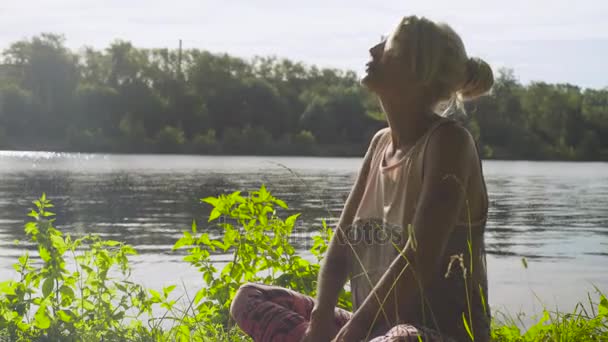 Femme faisant des exercices de yoga sur la rive de la rivière — Video
