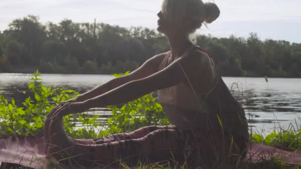 Nehir kıyısında üzerinde yoga egzersizleri yapıyor kadın — Stok video