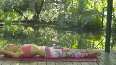 Çekici kadın yoga egzersizleri açık havada yapıyor