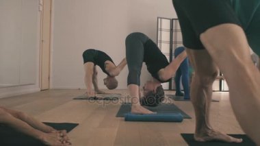 Bir grup insan yoga asanas Studio yapıyor