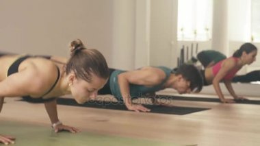 Bir grup insan yoga asanas Studio yapıyor