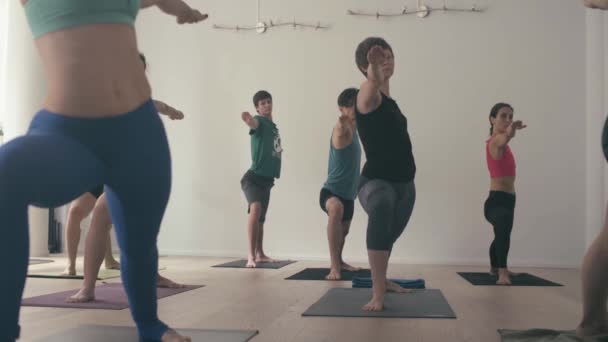 Grupo de personas haciendo asanas de yoga en estudio — Vídeos de Stock