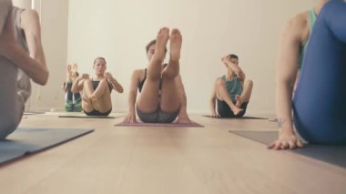 Bir grup insan yoga asanas Studio yapıyor