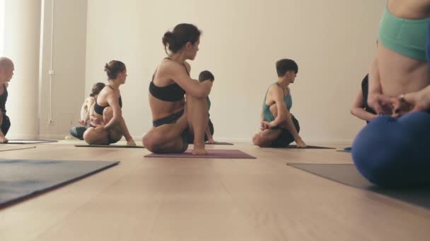 Group of people doing yoga asanas in studio — Stock Video