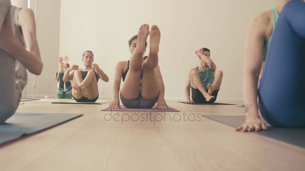 Group of people doing yoga asanas in studio — Stock Video