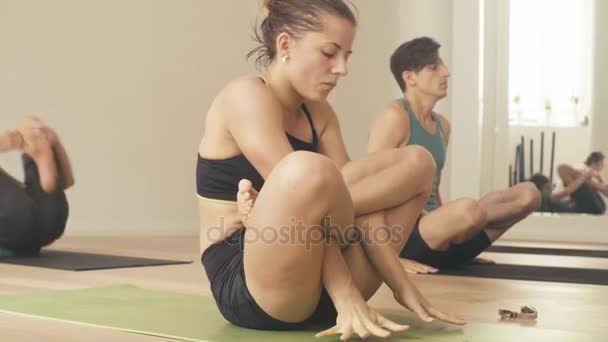 Estudiantes realizando tolasana en una clase de yoga — Vídeo de stock