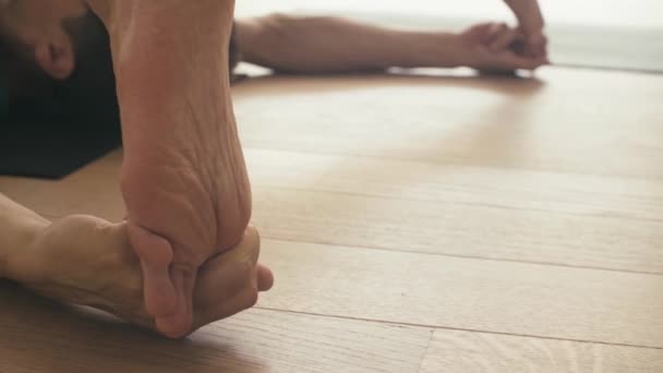 Foten av en man som gör yoga asana. — Stockvideo