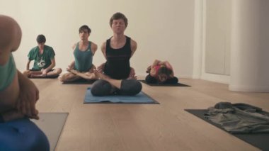 Bir grup insan yoga asanas Studio yapıyor
