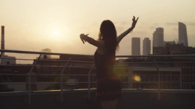 Genç çiftin günbatımı üzerinde dans siluetleri