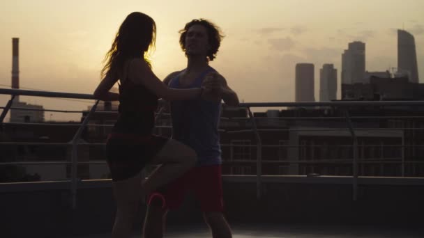 Siluetas de pareja joven bailando al atardecer — Vídeos de Stock