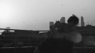 Genç çiftin günbatımı üzerinde dans siluetleri