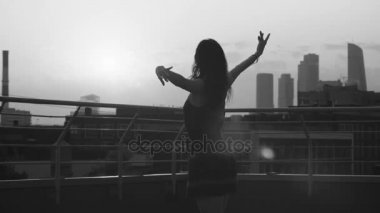 Genç çiftin günbatımı üzerinde dans siluetleri