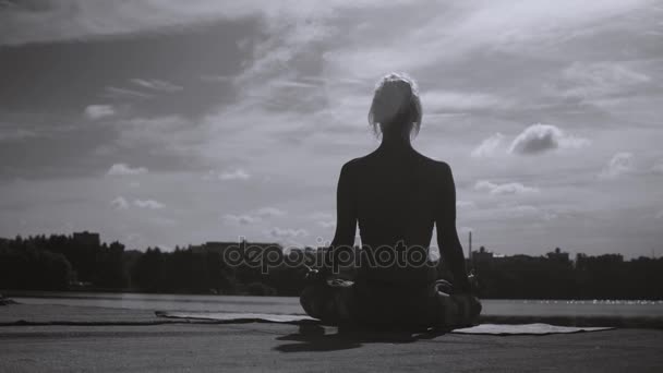 Молодая женщина медитирует в парке — стоковое видео