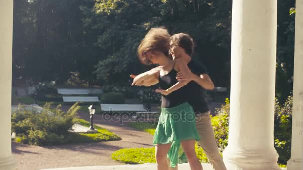 Молодая пара танцует в парке — стоковое видео
