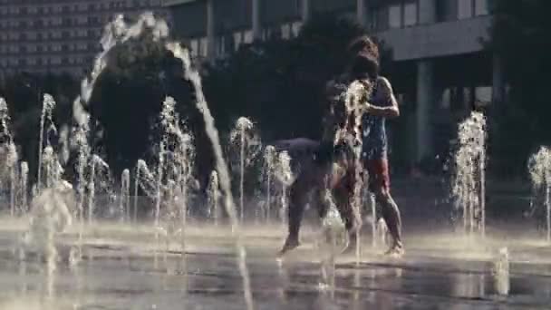 Mladý pár šťastný tanec ve fontáně — Stock video