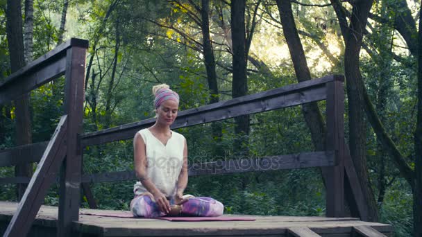 Mulher sentada na ponte velha com tigela cantando — Vídeo de Stock
