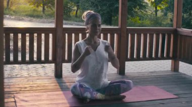 Çekici kadın Yoga asanas sunset bulvarında yapıyor