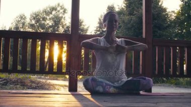 Çekici kadın Yoga asanas sunset bulvarında yapıyor