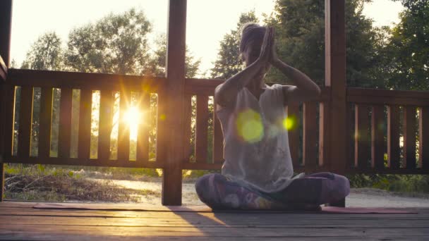 Aantrekkelijke vrouw doen yoga asana's op zonsondergang — Stockvideo