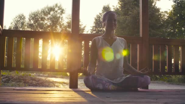 Attraktive Frau macht Yoga-Asanas bei Sonnenuntergang — Stockvideo