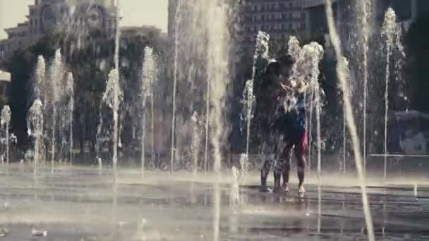 Unga lyckliga par stående i fontänen — Stockvideo