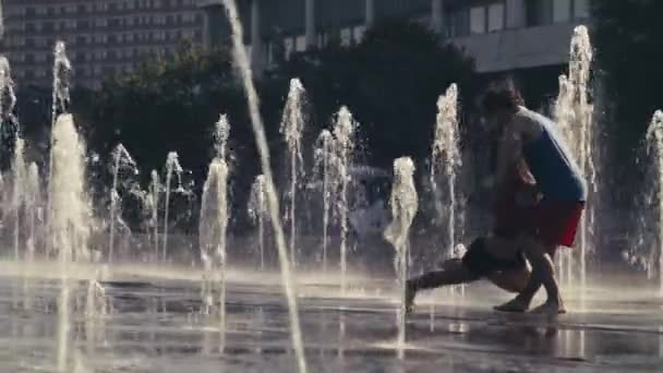 Jonge gelukkige paar dansen in de fontein — Stockvideo