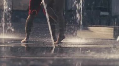 Genç çift fıskiyede dans edenlerin bacaklarını