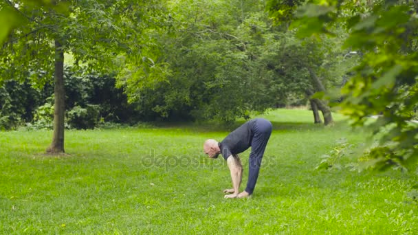 Un uomo che fa esercizi di yoga nel parco — Video Stock