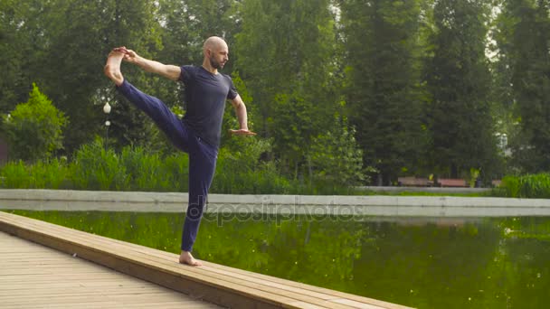 Hombre fuerte realizando un equilibrio de pie de una pierna — Vídeos de Stock