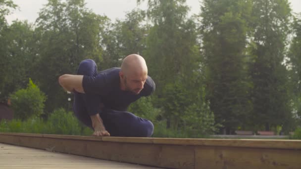Egy ember csinálás jóga gyakorlatok a parkban — Stock videók